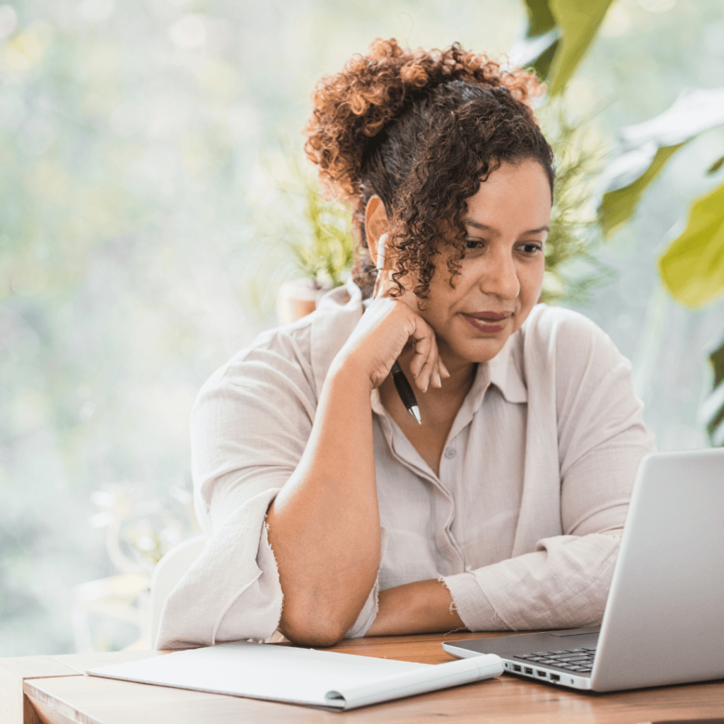 A woman with a laptop in front of her, conducting a virtual meeting