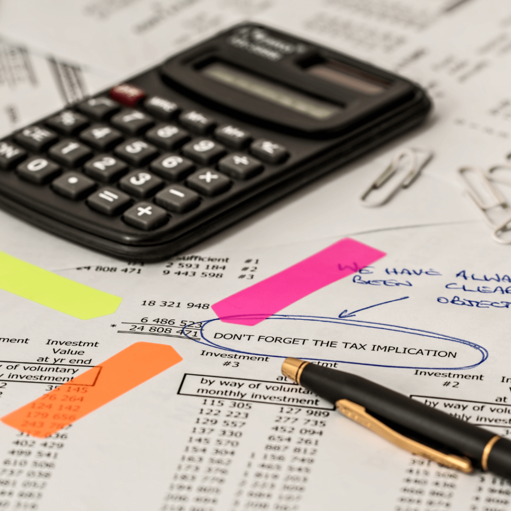 A calculator and colorful sticky notes on top of a tax form